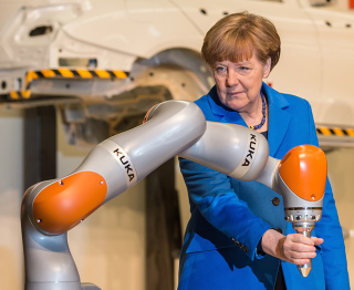 Illustration for article titled Why Is Angela Merkel Always Palling Around With Robots?